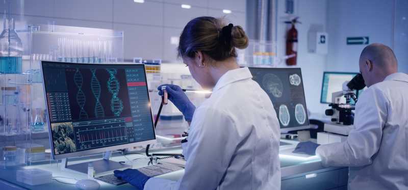 Lab technician viewing DNA analysis on computer