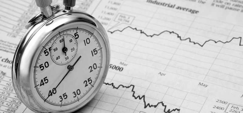 Stopwatch and stock market charts.