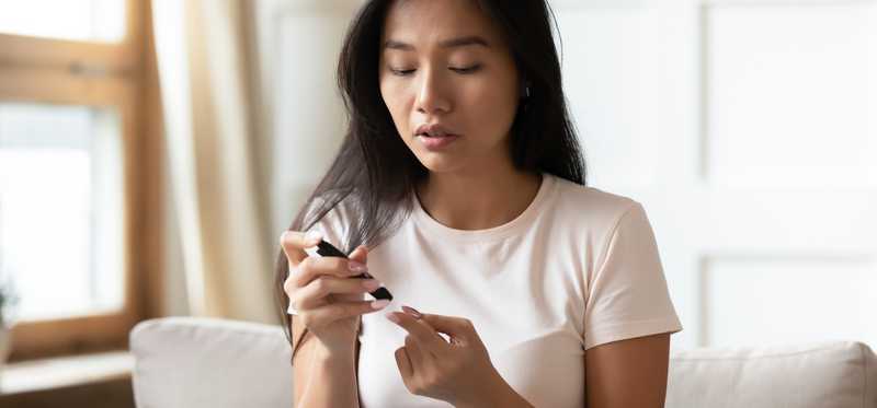 Person checking insulin with portable blood glucose meter.