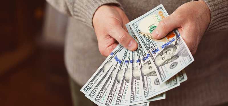 Man holding hundred dollar bills.