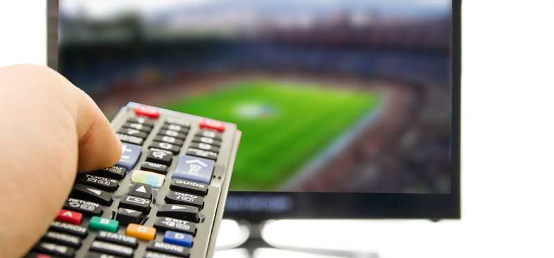 Person aiming remote at TV.