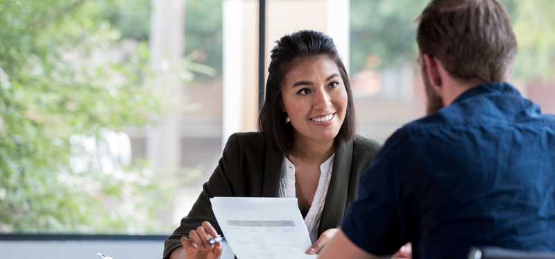 Insurance representative reviewing paperwork with client