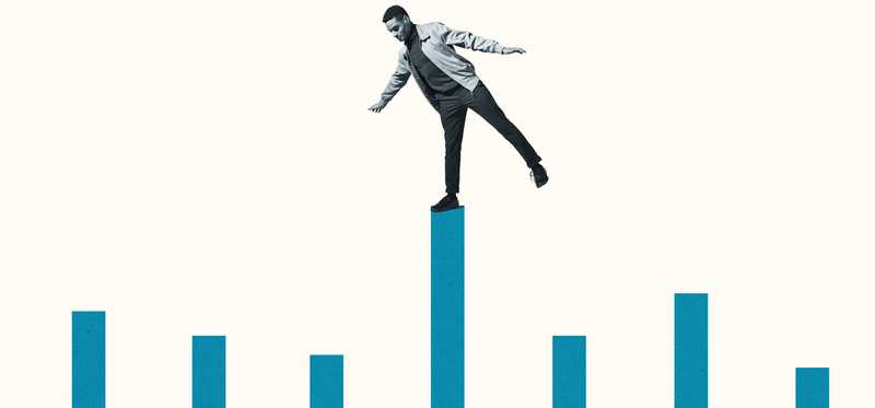 Person balancing on bar chart looking down.