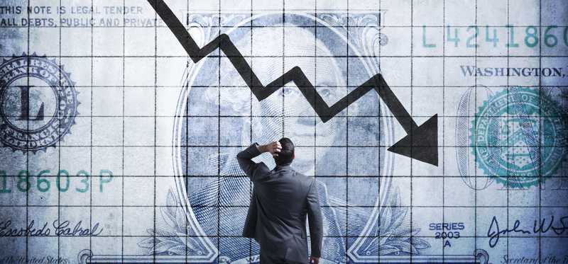 Businessperson watching the value of the dollar go down.