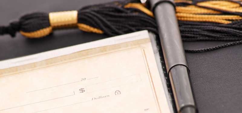 Checkbook, pen, and mortarboard graduation tassel