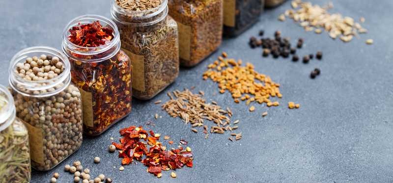 Mason jars filled with colorful spices and lined up in a row
