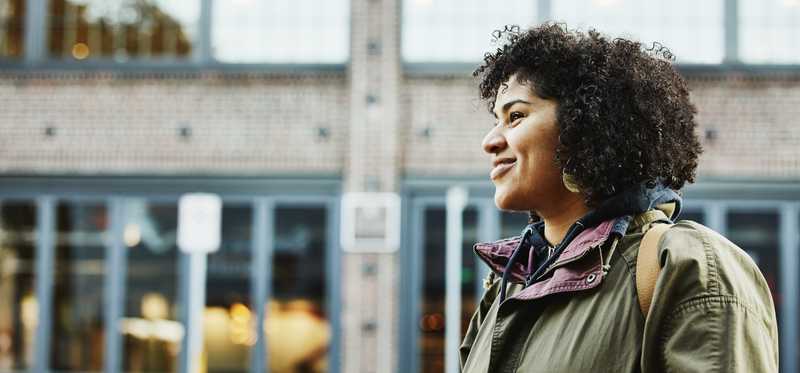 Smiling woman walking past building
