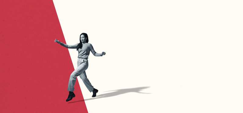 Young woman leaping from white marked space to red marked space