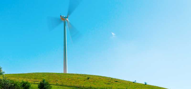 Windmill spinning above a valley.