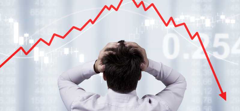 Anxious investor holds head while watching stock prices decline.