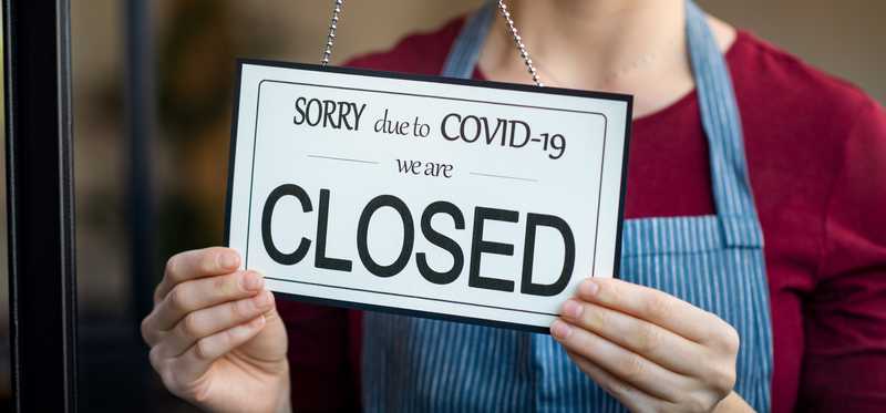 Door sign alerting of business closure due to COVID-19.