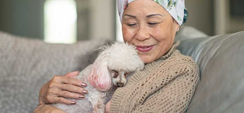 Person smiling while holding a poodle.