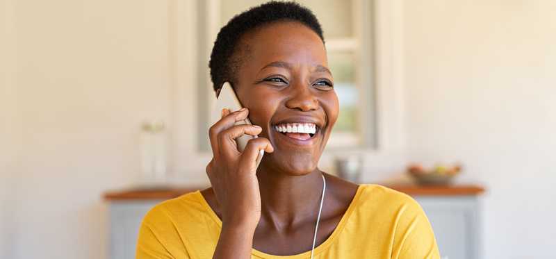 Smiling person talking on phone.