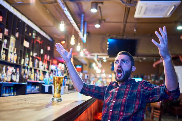 A man celebrates in a sports bar