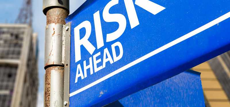 A blue sign that says Risk Ahead.