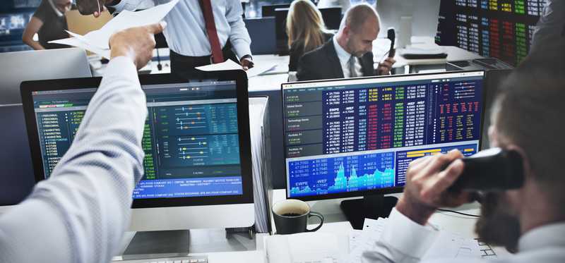 Stock traders working on computers and talking on the phone.