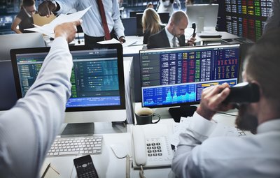 Stock traders working on computers and talking on the phone.