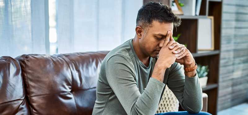 Stressed person sitting on a couch.