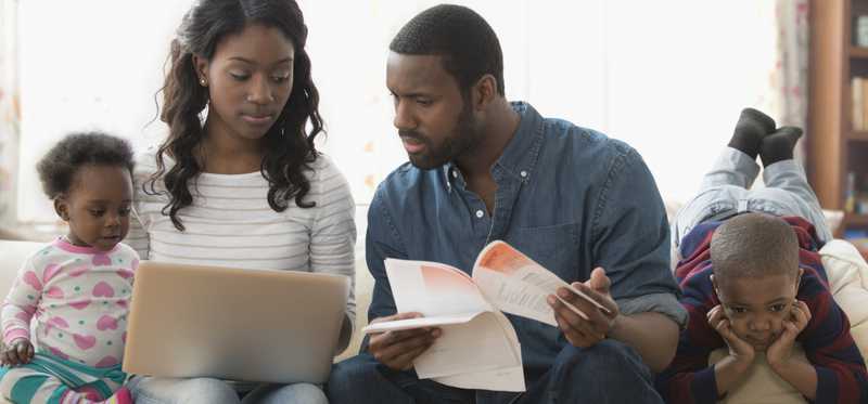 Stressed adults with two kids are holding papers and looking at laptop.