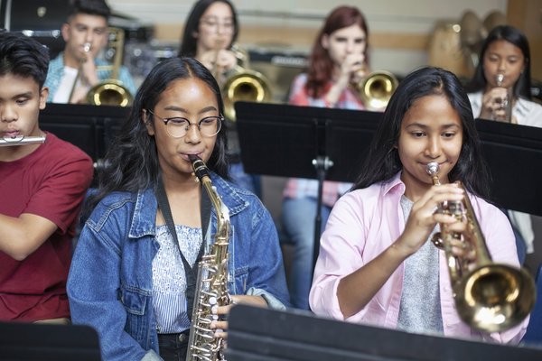 Students play brass instruments in school band.