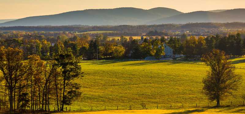 Sunny farmland and distant mountains.