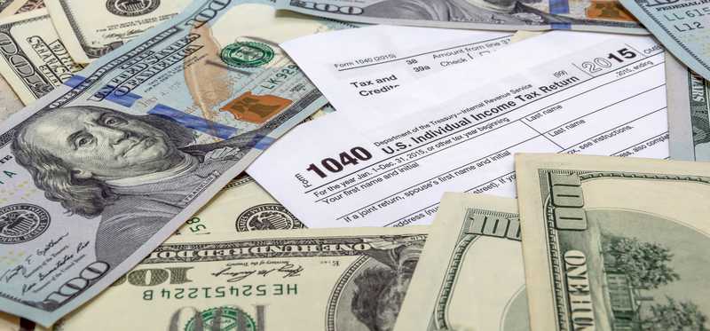 1040 tax form with money on top.