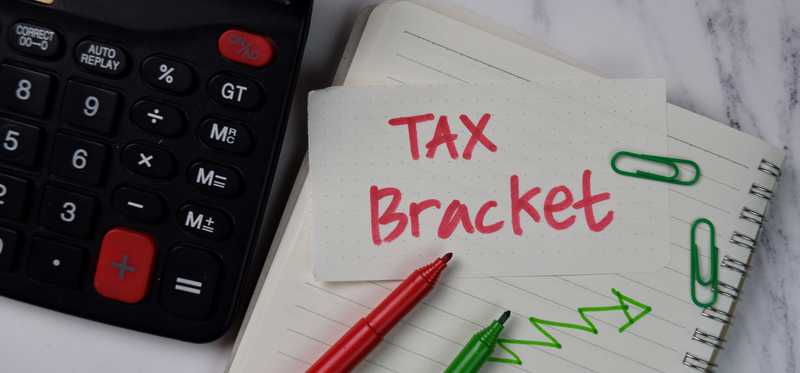 Sticky note saying Tax Bracket next to calculator.