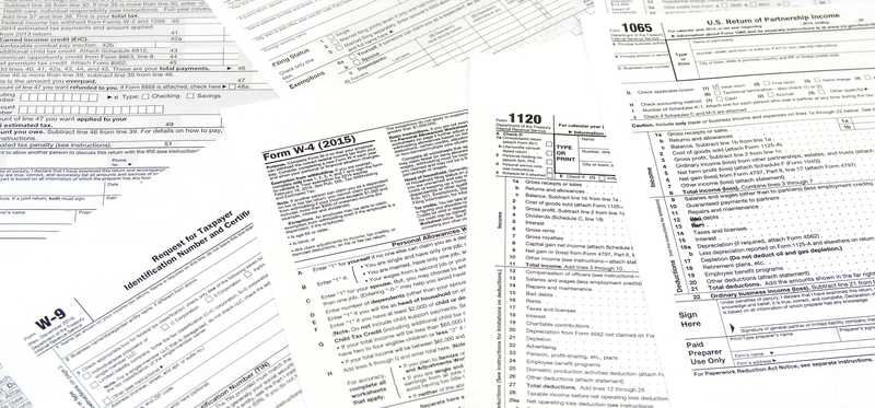 Various tax forms lay scattered in a pile.