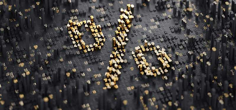 Percentage sign made up of gold particles on a black background.