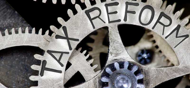 Metal clockwork gears with Tax Reform engraved on one.