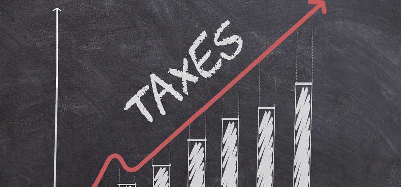 A bar graph on a chalkboard showing taxes are increasing.