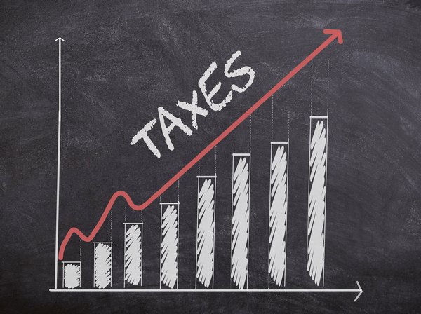 A bar graph on a chalkboard showing taxes are increasing.