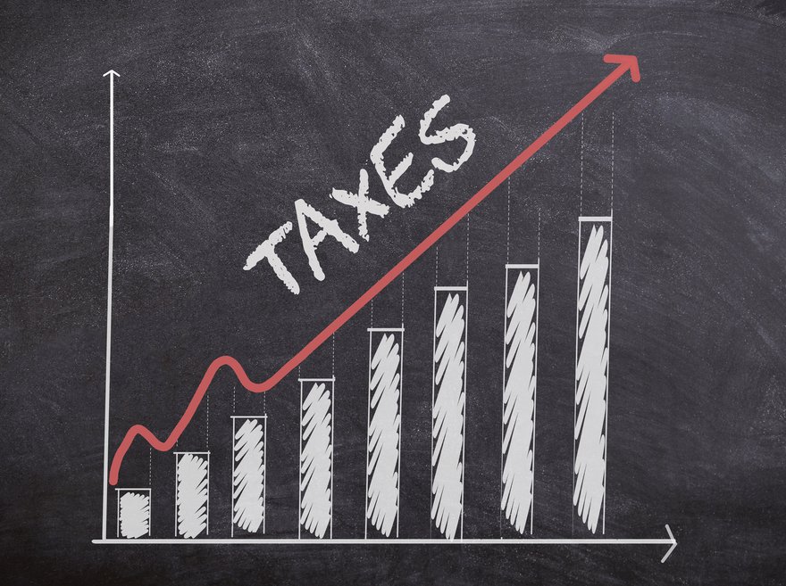 A bar graph on a chalkboard showing taxes are increasing.