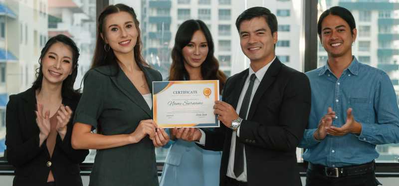 Team of employees posing with a certificate.