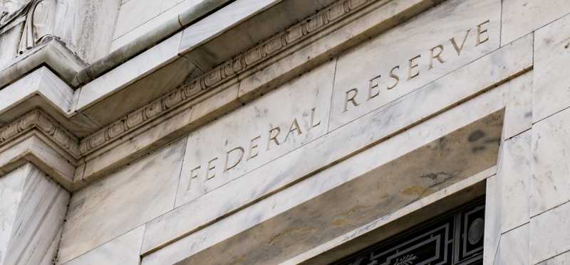 The facade of a building that says Federal Reserve on it.