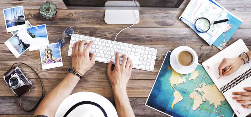 Person using a computer to book a trip online.