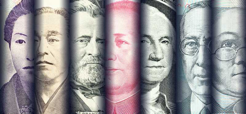 U.S. and foreign banknotes rolled up next to one another.