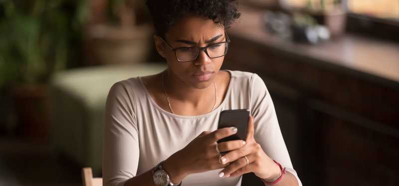 Upset person looking at phone screen.