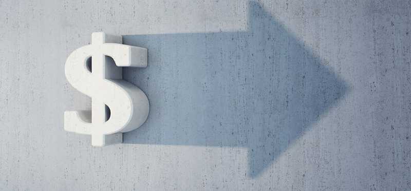 A dollar sign projecting a shadow of an arrow.