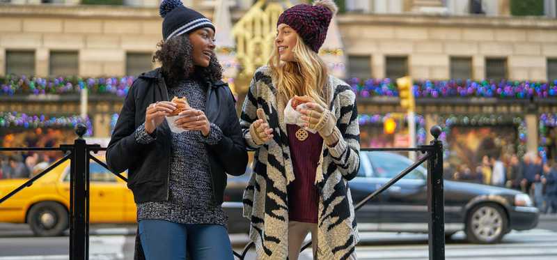 Two women wearing clothes from Wet Seal standing on the street of a big city