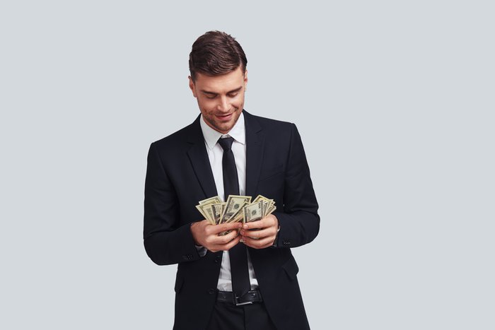 Wealthy man in suit counting his money