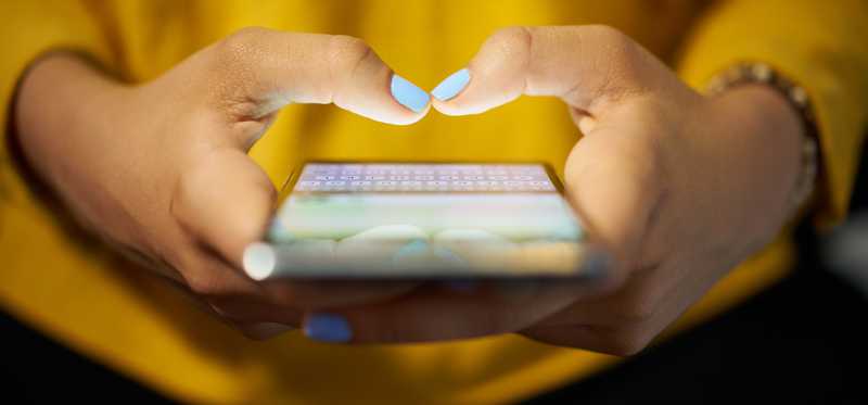 A person types on a smartphone.
