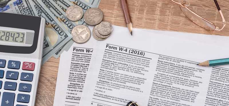 Tax form w4 with calculator, money, and pencil