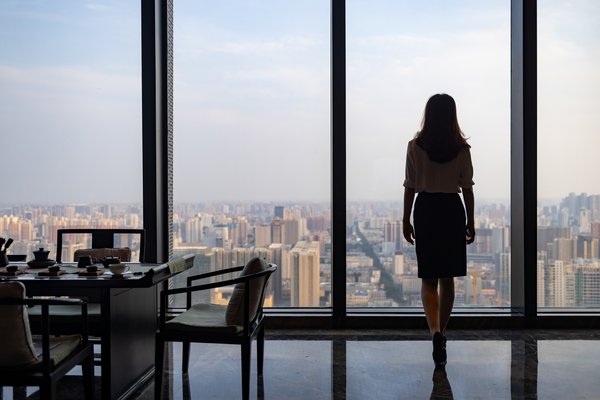 Woman executive overlooks large city from top of skyscraper
