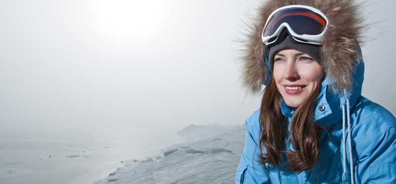 Woman in a blue parka outdoors.