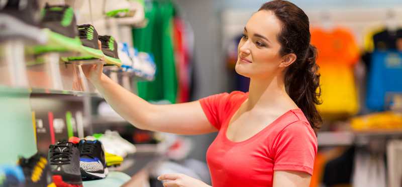 Person looking at sneakers in a clothing store.