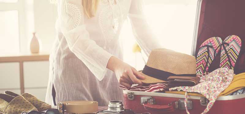 Person packing a suitcase.