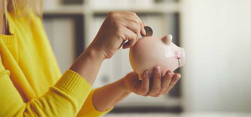 Woman putting money in piggy bank