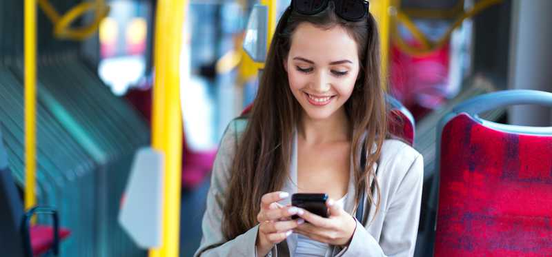 Woman using her smartphone on a bus.