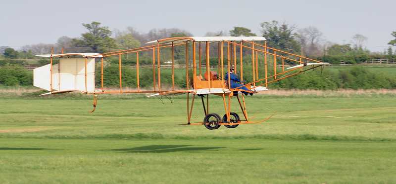 A replica of the Wright Brothers' plane in flight.